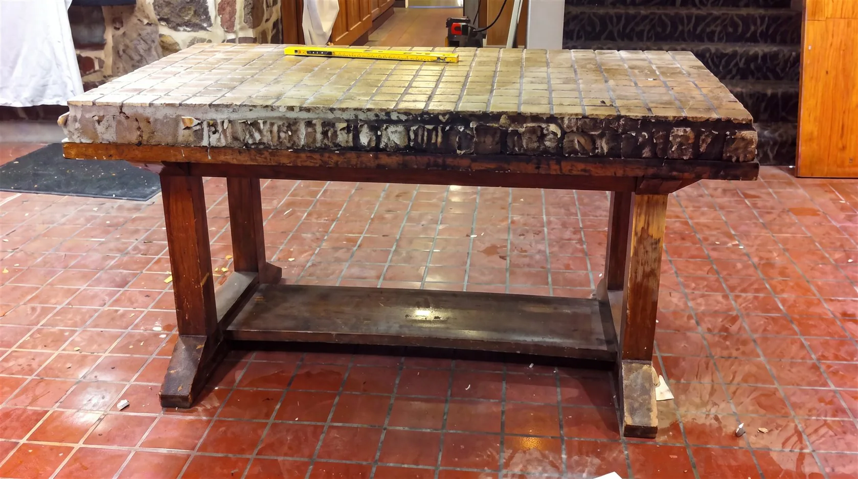 Dining table with tile-covered surface before restoration